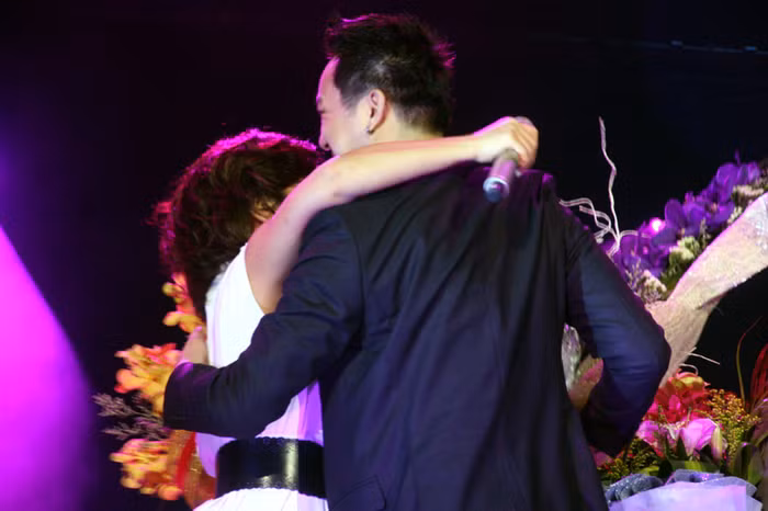 Và, một người lặng lẽ chăm chú ngồi xem Mỹ Linh dưới khán phòng lập tức lên tặng hoa chị, không ai khác chính là Huy MC.