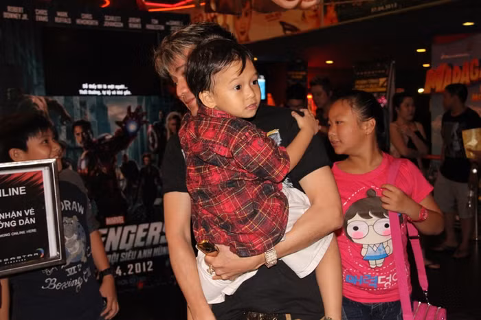 Mr Đàm dẫn hai con trai nuôi bước vào rạp phim. Họ bước đi khá nhanh, cố tránh sự hiếu kỳ của người hâm mộ. (Giaoduc.net.vn)