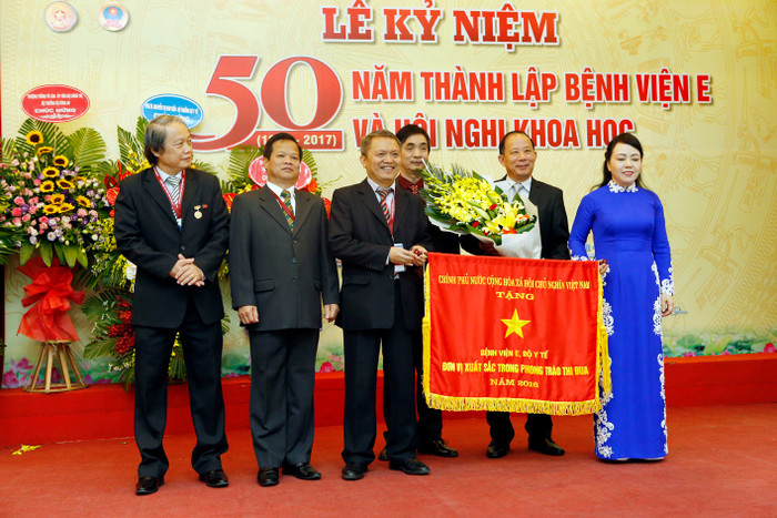 Trong lễ kỷ niệm 50, Bệnh viện E nhận Cờ thi đua của Chính phủ là đơn vị xuất sắc trong phong trào thi đua. Ảnh: Bệnh viện E. Trong lễ kỷ niệm 50, Bệnh viện E nhận Cờ thi đua của Chính phủ là đơn vị xuất sắc trong phong trào thi đua. Ảnh: Bệnh viện E.