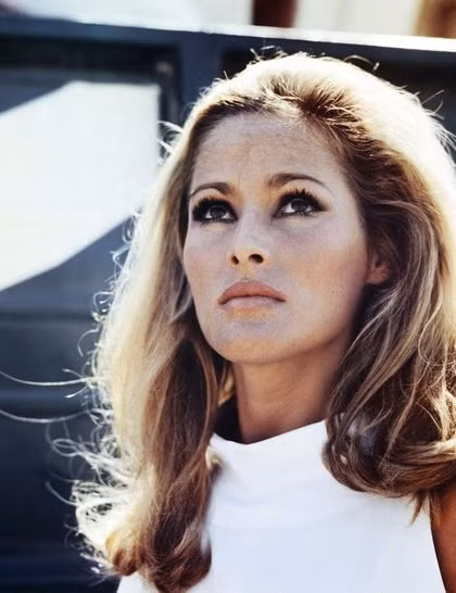 1. Honey Ryder (do Ursula Andress đóng), tập phim Dr No (1962) Để thực hiện kiểu tóc thời thượng của những năm 60 này, bạn cần chuẩn bị: máy sấy, lược đánh rối, máy uốn xoăn và keo xịt tạo kiểu. Cách làm như sau: - Chải hất toàn bộ tóc về phía sau rồi đánh rối phần tóc trên đỉnh đầu. - Uốn xoăn vểnh phần đuôi tóc - Xịt gel tạo kiểu lên toàn bộ mái tóc để giữ nếp