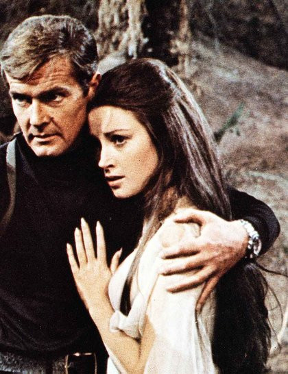 4. Solitaire (do Jane Seymour), tập phim Live & Let Die (1973) Kiểu tóc nữ tính này dành riêng cho các cô gái có mái tóc dài thẳng mượt. Cách làm như sau: - Chải toàn bộ phần tóc mái ra sau rồi thoa tinh dầu dưỡng cho cả mái tóc, tạo sự mềm, mượt. - Kéo tóc ở hai bên mai ra phía sau rồi dùng cặp ghim cố định ở phía trên đỉnh đầu.
