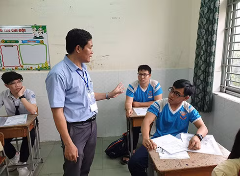 Điểm trưởng Tống Văn Tạo nhắc nhở thí sinh sử dụng máy trợ thính ở phòng thi 2928 (ảnh: P.L)