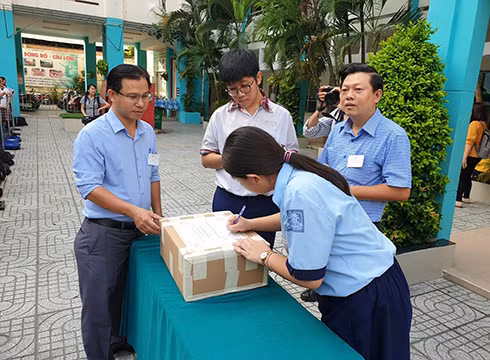 Thí sinh kiểm tra đề thi vẫn còn nguyên niêm phong ở điểm thi Trường Điện Biên (ảnh: P.L)