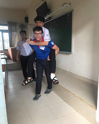 Nam thí sinh được sinh viên Khôi cõng lên tận phòng thi (ảnh: VHU) Nam thí sinh được sinh viên Khôi cõng lên tận phòng thi (ảnh: VHU)