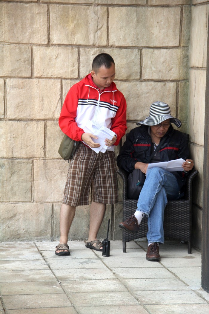 MC Lại Văn Sâm đội mũ rộng vành, ngồi kín đáo trong một góc tường bàn công việc.