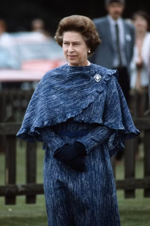 Nữ hoàng Elizabeth II diện váy và chiếc khăn choàng lớn cùng màu sắc, chất liệu năm 1984.