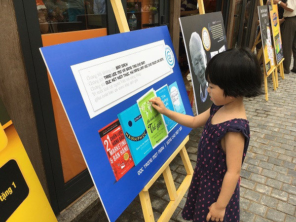 Một em nhỏ mê mẩn với những hình ảnh giới thiệu sách.