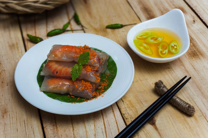 Lớp bột lọc trong veo bao lấy nhân tôm thịt xào đậm đà gói trong những chiếc lá chuối, ăn cùng nước mắm chấm cay nồng tạo nên hương vị càng thơm ngon và dân dã đậm chất quê hương. Lớp bột lọc trong veo bao lấy nhân tôm thịt xào đậm đà gói trong những chiếc lá chuối, ăn cùng nước mắm chấm cay nồng tạo nên hương vị càng thơm ngon và dân dã đậm chất quê hương.