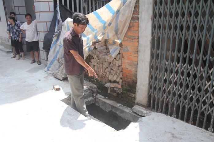 Người đàn ông chỉ xuống chiếc hố, anh đã từng bị ngã khi đi qua đây vào ban đêm