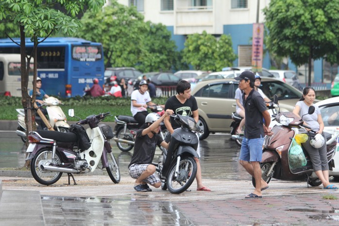 Bạn trẻ này đang loay hoay sửa chữa vì xe không thể nổ được do nước ngập vào ống xả và bị ướt bugi Bạn trẻ này đang loay hoay sửa chữa vì xe không thể nổ được do nước ngập vào ống xả và bị ướt bugi