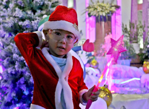 Em bé thích thú khi được mặc đồ ông già Noel trong dịp Giáng sinh về (ảnh: T.P)