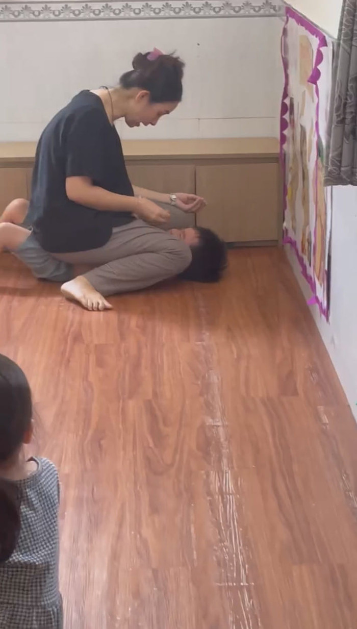 Hành vi đè trẻ ra, nhét thức ăn vào miệng của cô giáo N. (ảnh cắt từ video clip) TiBo.jpg