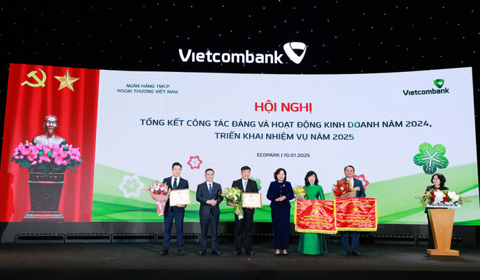 Bà Nguyễn Thị Hồng - Ủy viên Ban Chấp hành Trung ương Đảng, Thống đốc Ngân hàng Nhà nước Việt Nam (thứ 4 từ trái sang) trao cờ Thi đua của Ngân hàng Nhà nước và Bằng khen Thống đốc cho 04 đơn vị của Vietcombank. 20250110_VCB_Tin Bai Hoi Nghi Tong Ket Kinh Doanh_anh 2.jpg