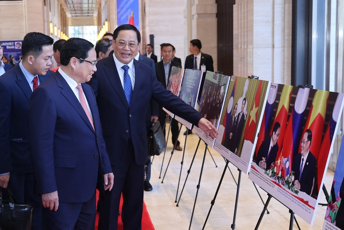 Thủ tướng Lào giới thiệu với Thủ tướng Phạm Minh Chính một số hình ảnh về hợp tác song phương Việt Nam-Lào. Ảnh: VGP/Nhật Bắc