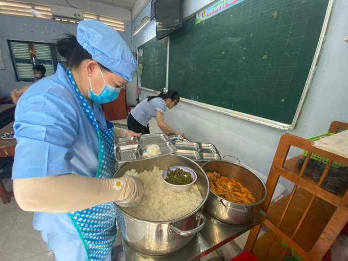 Bảo mẫu chia đồ ăn cho từng học sinh tại các lớp (ảnh: P.L)