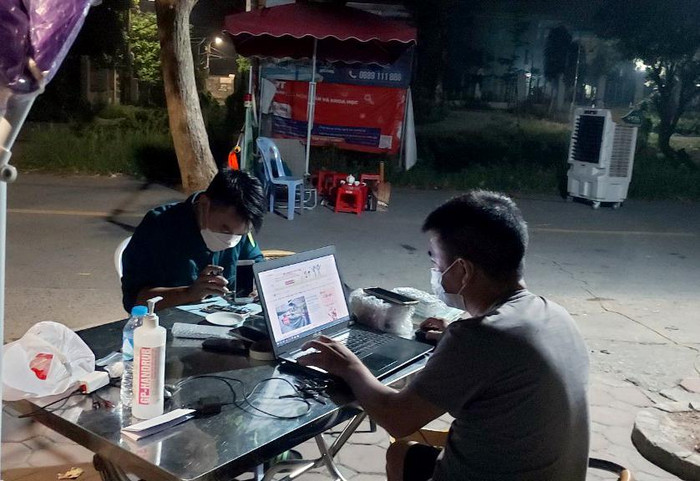 Thầy Dũng và anh Tiến tranh thủ sửa điện thoại trong buổi trực chốt đêm. (Ảnh: Nhân vật cung cấp). Thầy Dũng và anh Tiến tranh thủ sửa điện thoại trong buổi trực chốt đêm. (Ảnh: Nhân vật cung cấp).
