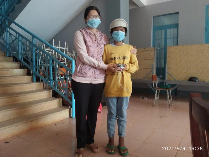 Cô Trần Thị Vân Huyền - Giáo viên Trường Trung học cơ sở Tân Lâm tặng điện thoại cho học sinh học trực tuyến. (Ảnh nhà trường cung cấp)