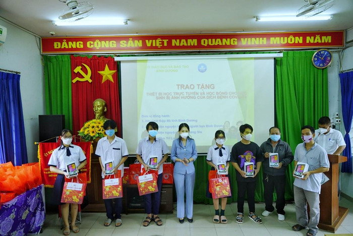 Giám đốc Sở Giáo dục và Đào tạo tỉnh Bình Dương Nguyễn Thị Nhật Hằng trao máy tính bảng cho học sinh có hoàn cảnh khó khăn ở thành phố Dĩ An (Bình Dương). Ảnh: Hữu Đức