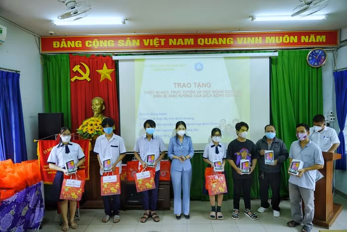 Giám đốc Sở Giáo dục và Đào tạo tỉnh Bình Dương Nguyễn Thị Nhật Hằng trao máy tính bảng cho học sinh có hoàn cảnh khó khăn ở thành phố Dĩ An (Bình Dương). Ảnh: Hữu Đức