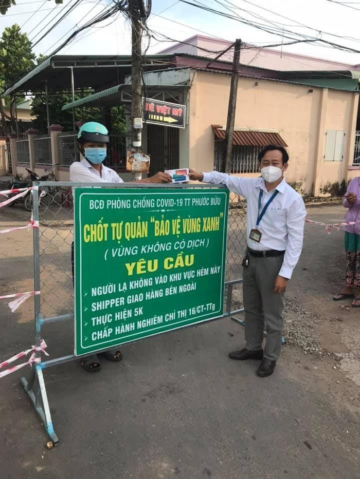 Thầy Lê Văn Chinh, Hiệu trưởng Trường Trung học cơ sở Phước Bửu trao điện thoại cho học sinh học trực tuyến (Ảnh nhà trường cung cấp)