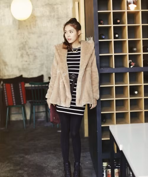 Chiếc váy bó kẻ đen-trắng bên trong, phối cùng legging và áo lông tạo vẻ trẻ trung, năng động.