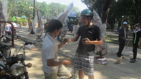 Khách hàng đang rất vui vẻ vì mua được một chậu hoa rẻ mang về nhà chưng tết từ công viên Gia Định (ảnh: P.L)