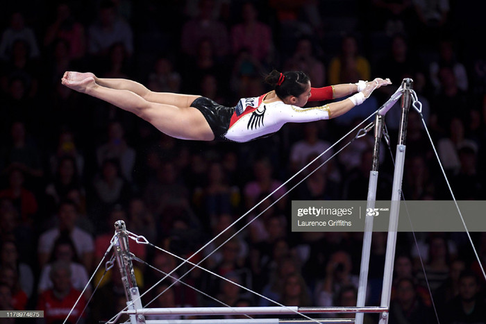 Kim Bui trình diễn nghệ thuật điêu luyện trên xà kép lệch (nguồn ảnh: Kim Bùi-Wikipedia và Facebook)