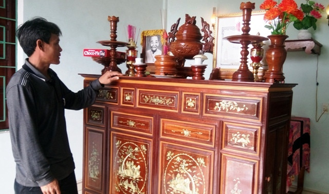 Anh Lợi bên bàn thờ của ông bà nuôi. (Ảnh: Thủy Phan) Anh Lợi bên bàn thờ của ông bà nuôi. (Ảnh: Thủy Phan)