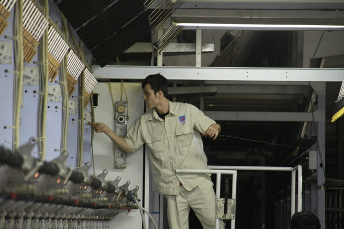 Các cuộn sợi đầu tiên được nối lên giàn kéo DTY. Các cuộn sợi đầu tiên được nối lên giàn kéo DTY.