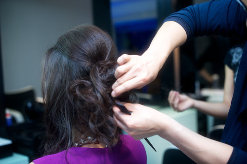 Phần tóc uốn được tạo kiểu búi gọn phía sau.