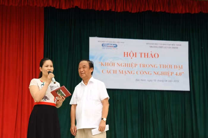 Giáo sư Nguyễn Lân Dũng tặng sách cho giáo viên. Ảnh: Vũ Phương.