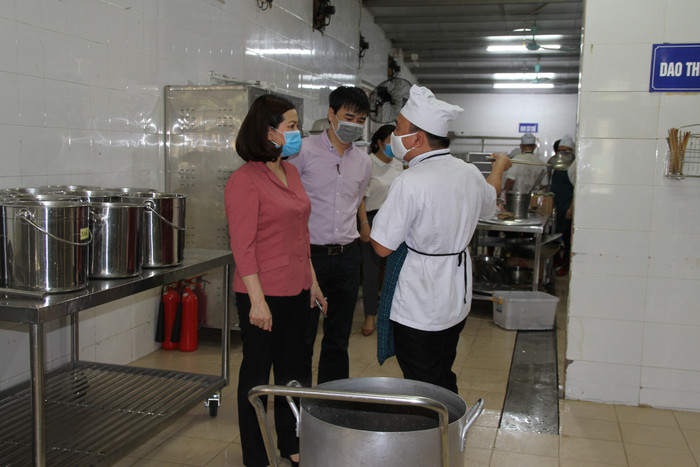 Bà Hương trao đổi với bếp trưởng nhà ăn Trường tiểu học Long Biên về công tác chế biến bữa ăn bán trú cho học sinh ngày đầu trở lại trường. Ảnh: Vũ Phương.