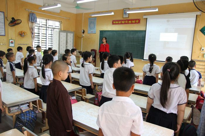 Học sinh nghiêm trang thực hiện nghi thức chào cờ đầu tuần trong lớp. Ảnh: Vũ Phương.