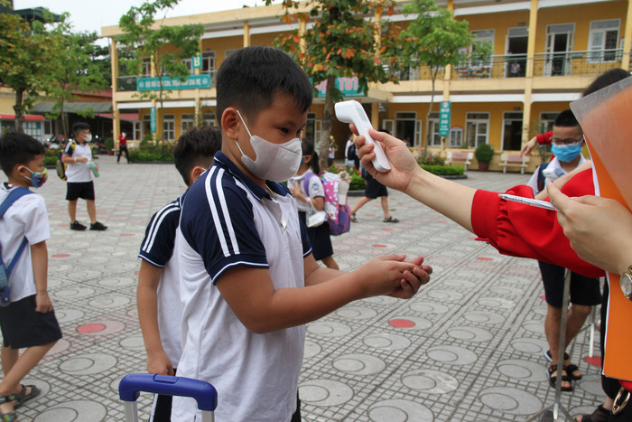 Ngoài việc đo thân nhiệt, học sinh rửa tay sát khuẩn trước khi vào lớp. Ảnh: Vũ Phương