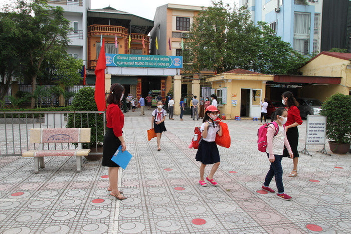 Học sinh vẫn thực hiện giãn cách, đeo khẩu trang khi đến trường. Ảnh: Vũ Phương