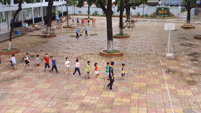 Giáo viên hướng dẫn học sinh thực hiện giãn cách phòng chống dịch. Ảnh: NVCC.