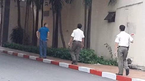 Bảo vệ Hùng (giữa) sau khi 'tiễn' phóng viên ra tới tận cổng trường nhanh chóng quay vô để tránh ống kính chụp hình (Ảnh: T.Q)