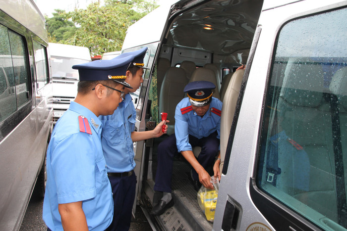 Cán bộ Đội Thanh tra giao thông quận Cầu Giấy kiểm tra chi tiết, kỹ càng các yêu cầu, điều kiện trên xe đưa đón học sinh trường Gateway. Ảnh: Vũ Phương.