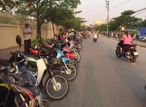 Phụ huynh xếp hàng trả lại đường thông hè thoáng cho người tham gia giao thông (Ảnh:V.N)