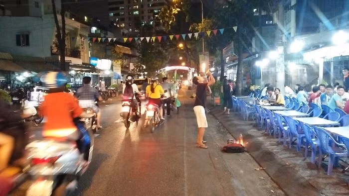 Cậu bé Thuận chuẩn bị biểu diễn màn thổi lửa (Ảnh: Vũ Ninh)