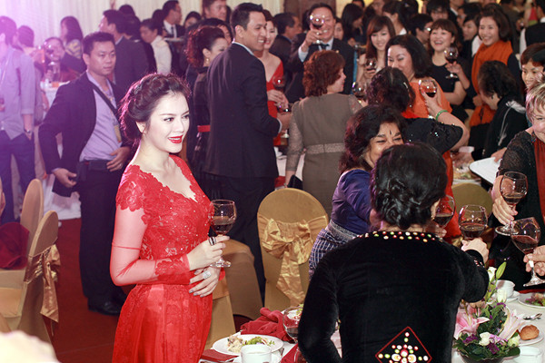 Trong buổi tiệc, cô vui vẻ đi chào hỏi mọi quan khách.