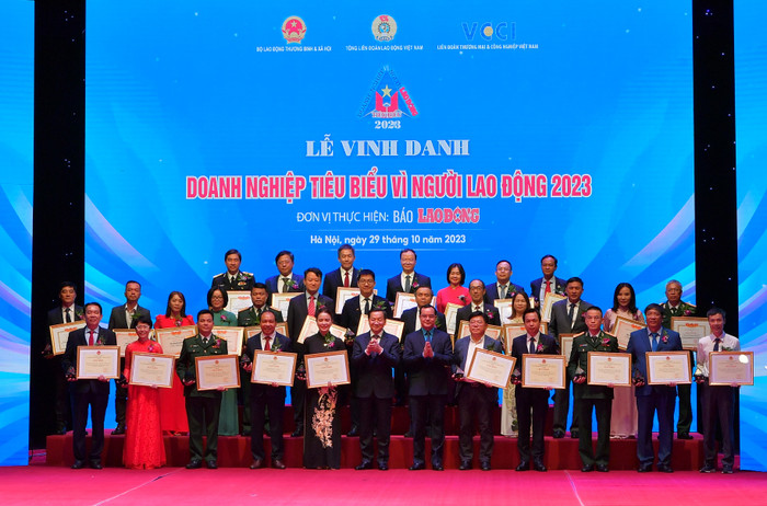 Phó Thủ tướng Lê Minh Khái (hàng đầu, thứ 6 từ trái sang) và Chủ tịch Tổng Liên đoàn Lao động Việt Nam Nguyễn Đình Khang (hàng đầu, thứ 6 từ phải sang) chụp ảnh kỷ niệm cùng ông Lê Quang Vinh - Phó Tổng Giám đốc Vietcombank (hàng 3, thứ 4 từ phải sang) và 29 doanh nghiệp khác được nhận Bằng khen “Doanh nghiệp tiêu biểu vì người lao động”.