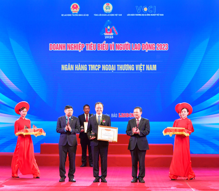 Ông Lê Văn Thanh - Thứ trưởng Bộ Lao động - Thương binh và Xã hội (bên phải) trao Bằng khen “Doanh nghiệp tiêu biểu vì người lao động” và ông Phan Văn Anh - Phó Chủ tịch Tổng Liên đoàn Lao động Việt Nam (bên trái) trao Kỷ niệm chương cho ông Lê Quang Vinh - Phó Tổng Giám đốc Vietcombank, đại diện Ngân hàng Thương mại Cổ phần Ngoại thương Việt Nam tại Lễ vinh danh.