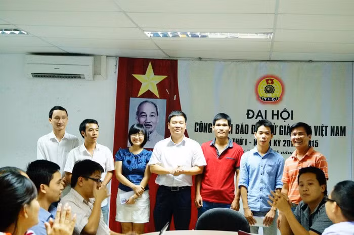 Tổng Biên tập Nguyễn Tiến Bình thưởng nóng cho các phóng viên xuất sắc trong một cuộc giao ban tuần năm 2012 để động viên cán bộ, phóng viên có nhiều bài viết hay. Ảnh: Xuân Trung