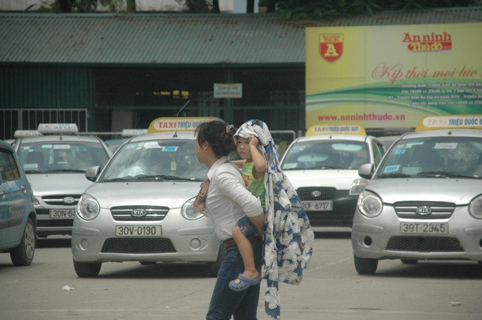 Người mẹ này đang loay hoay cõng đứa con nhỏ sang đường vì quá đông xe cộ