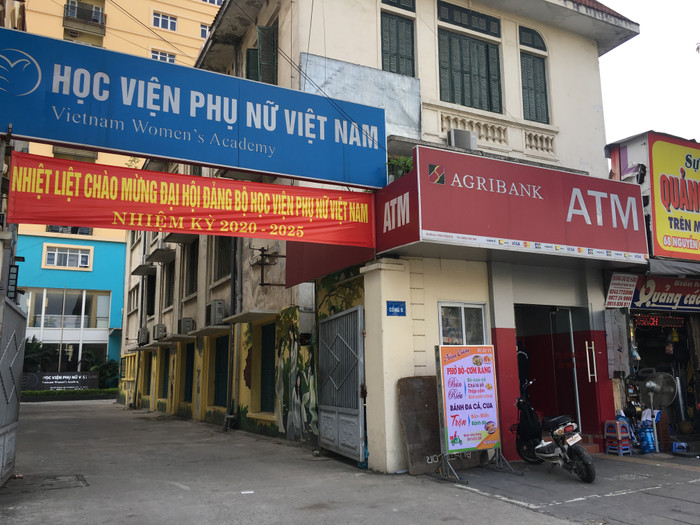 Cổng B của Học viện Phụ nữ Việt Nam lọt thỏm giữa những hàng quán thuê mặt bằng của Học viện. Ảnh: Vũ Phương. Cổng B của Học viện Phụ nữ Việt Nam lọt thỏm giữa những hàng quán thuê mặt bằng của Học viện. Ảnh: Vũ Phương.