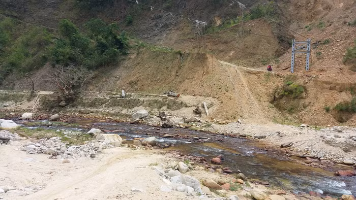 Cây cầu tạm bắc qua suối đã sập, con đường từ trường đi đến các bản phải lội qua suối, vào hôm trời mưa nước dâng cao không thể đi qua. Ảnh: NVCC.
