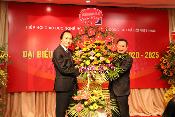 Thứ trưởng Bộ Lao động - Thương binh và Xã hội Lê Văn Thanh (bên phải) tặng lẵng hoa chúc mừng Đại hội Đại biểu lần thứ III của Hiệp hội Giáo dục nghề nghiệp và nghề công tác xã hội Việt Nam