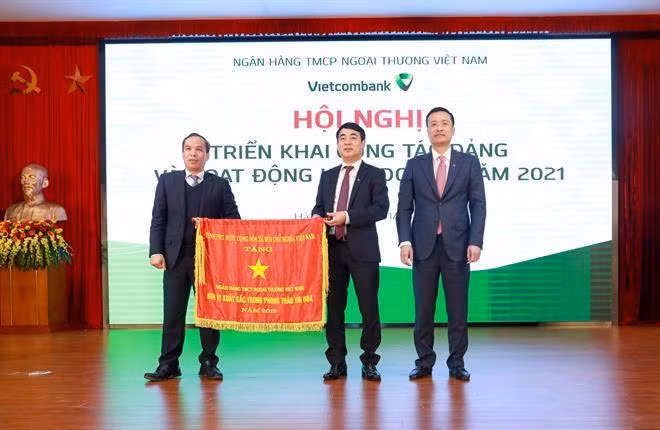 Thừa ủy quyền của Thủ tướng Chính phủ, Phó Thống đốc Ngân hàng Nhà nước Đoàn Thái Sơn trao Cờ thi đua của Thủ tướng Chính phủ cho Vietcombank tại Hội nghị triển khai hoạt động kinh doanh năm 2021 của Vietcombank.