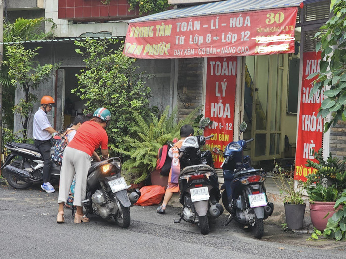 Sau giờ tan học là phụ huynh chở học sinh đến các lớp học thêm buổi chiều (ảnh: V.D) gdvn_daythemTT.jpg